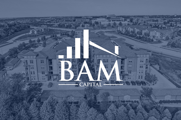 Aerial view of an apartment complex with trees and parking, overlaid with the BAM Capital logo featuring stylized building graphics and text.