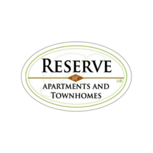 An oval logo with the text “Reserve Apartments and Townhomes” in bold black letters, featuring a gold accent and a small accessibility icon in the bottom right corner.