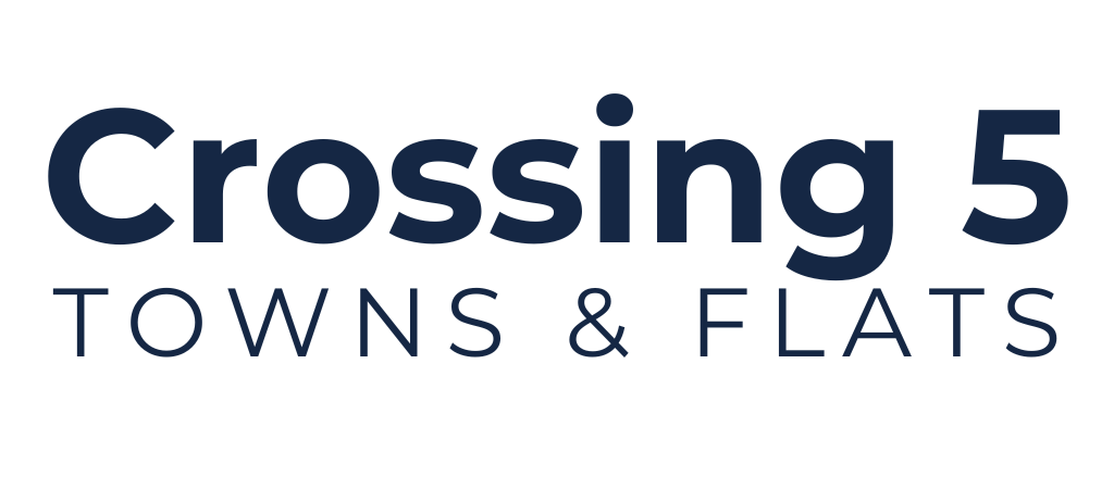 The image displays the text Crossing 5 TOWNS & FLATS in bold, dark blue letters on a light background.