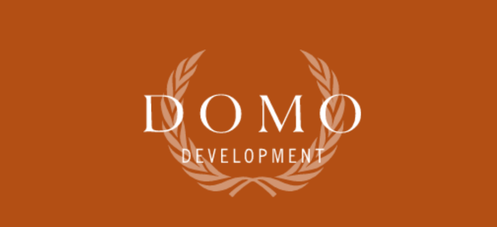 White text DOMO DEVELOPMENT is centered on a solid brown background, with a laurel wreath graphic partly encircling the text from both sides.